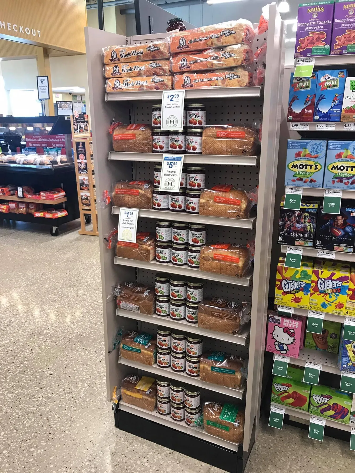 A grocery shelf of bread with jars of Autumn Berry Jam on display.